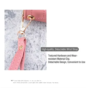 Détail du portefeuille rose montrant le fermoir doré et la dragonne avec coutures fines