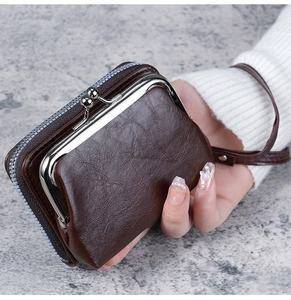 Detail of dark brown vintage coin purse with silver metal clasp and leather wrist strap