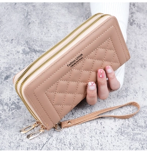 Détail d'un long portefeuille en cuir PU matelassé rose avec double fermeture éclair