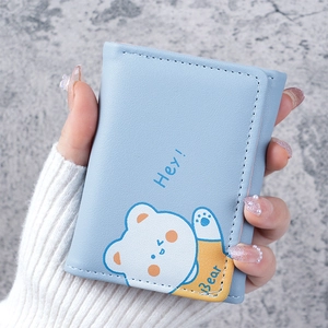 Close-up of a light blue compact tri-fold wallet featuring a cute cartoon bear illustration