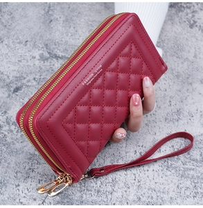 Détail du portefeuille long en cuir PU bordeaux matelassé avec double zip et dragonne