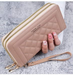 Détail du portefeuille en cuir matelassé rose avec double fermeture éclair et dragonne amovible