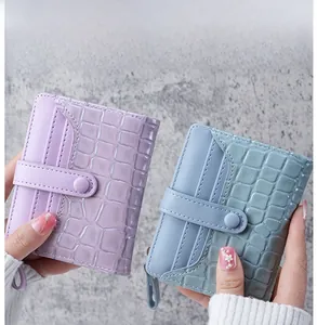 Detail view of women short wallet with stone and crocodile pattern texture in blue and purple