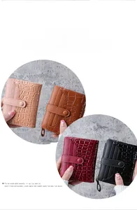 Detail of short wallets with crocodile pattern, card slots, and zip closure for women