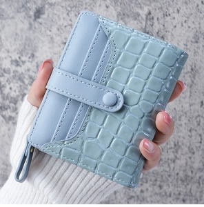 Detail of mint green crocodile embossed texture and matte finish on short wallet