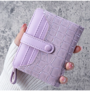 Detail of purple croc-effect wallet with snap closure and side leather card slots