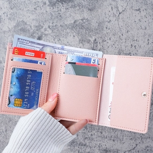 Pink three-fold leather wallet featuring multiple card slots and a clear ID window
