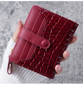 Close-up of deep burgundy faux crocodile leather wallet with snap button and zipper