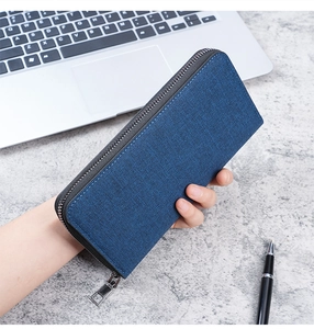 Close-up of blue canvas business wallet showing fabric texture and smooth metal zipper