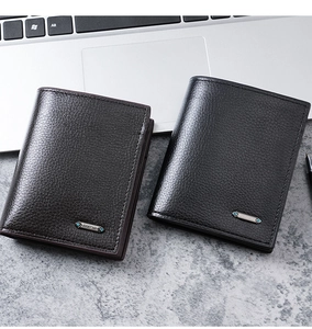 Close-up of black and brown leather bifold wallets on a desk with premium metal logo
