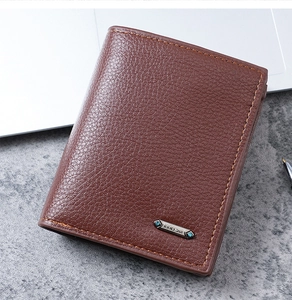 Close-up of brown PU leather men's wallet with lychee grain texture and metal logo