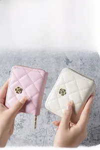 Close-up of quilted pink and beige accordion card wallets with gold flower accents