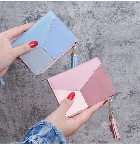 Detailed close-up of two bicolor women's wallets with chic tassels and contrast stitching