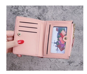 Close-up of pink bi-fold wallet featuring multiple card slots and a transparent ID window