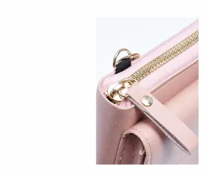 Detail of smooth gold zipper and soft pink leather texture on a crossbody bag