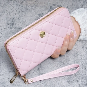 Détail du portefeuille matelassé rose avec logo fleur dorée et dragonne femme