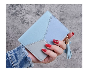 Detailed view of women's tri-color wallet with geometric stitching and tassel zipper