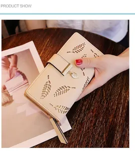 Detail of leaf hollow-out design and metal leaf pendant on beige long wallet