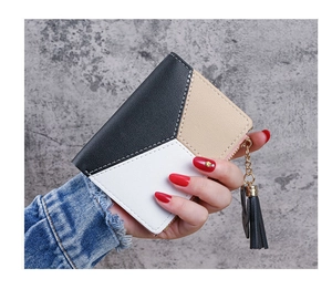 Detail of a tri-color patchwork short wallet with tassel zipper and metal ring accent