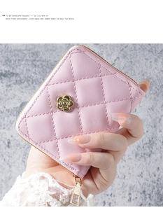 Detail of pink quilted wristlet wallet with gold camellia charm and zip closure