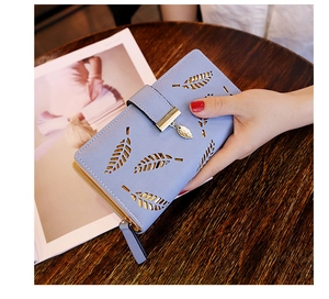 Detalle del diseño de hoja calada con láser en la cartera larga azul claro para mujer