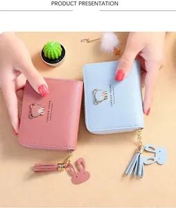 Detail of pink and blue short tassel wallets with gold bear buckles and cute rabbit charms