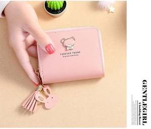 Pink mini wallet detail showing the zipper, metal bear logo and leather tassel charm