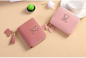 Close-up of mini wallets with tassel charms and bear metal accents in pink