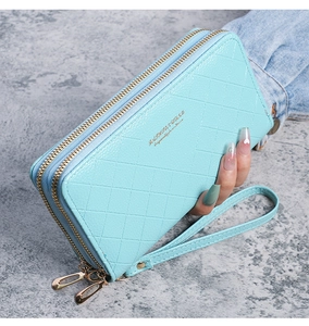 Detail of light blue quilted leather wallet with double gold zippers and wrist strap