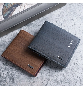 Detail of short leather wallets in grey and brown with striped texture and metal plates