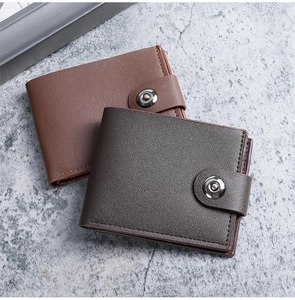 Close-up of leather men's bifold wallets in brown and grey with metal snap button closure
