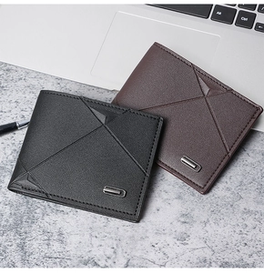 Close-up of minimalist bi-fold wallets in black and brown leather on a textured stone surface