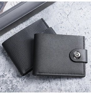 Detailed close-up of two men's black pebbled faux leather wallets on a stone surface