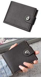 Detail of dark brown leather bifold wallet with button closure and pebble grain texture