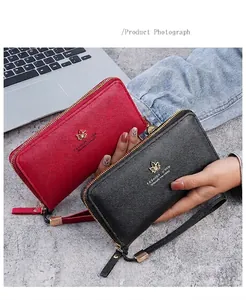 Détail de longs portefeuilles zippés en cuir rouge et noir avec emblème de feuille d'érable