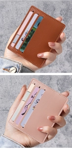 Detail view of ultra-thin leather card holders in brown and pink with litchi texture