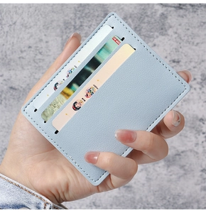 Detail of light blue lychee pattern leather card holder with precise white stitching