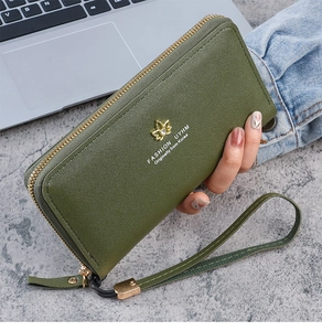 Détail du portefeuille en cuir vert foncé avec logo lotus doré et dragonne zippée