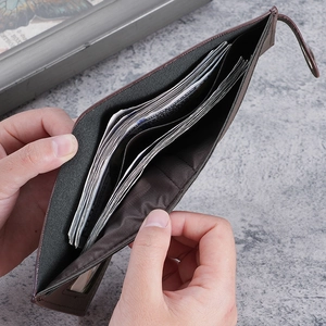Men's brown short folding wallet with card slots and snap closure on marble background