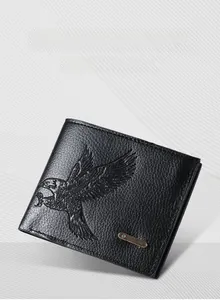 Detailed view of black leather wallet featuring eagle embossed pattern and metal logo