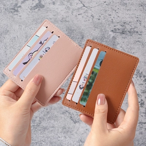 Slim pink and brown leather card holders held in hand showing compact multi-slot design