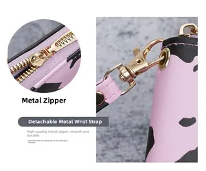 Close-up of pink cow print wallet featuring a gold zipper and detachable wrist strap