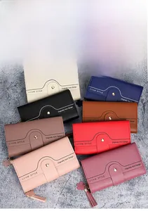 Multiple colorful long wallets with clover tassels and snapshots on a textured background