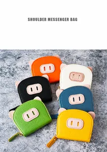 Flat lay of six colorful pig-shaped coin purses with lychee grain leather and ear detail