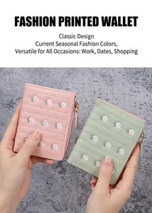 Dettaglio di portafogli pieghevoli corti con delicate ricami floreali in rosa e verde menta