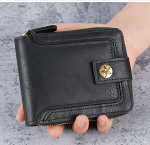 Close-up of black leather wallet texture with star metal buckle and zip closure