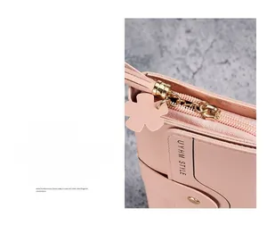 Detail of pink faux leather wallet featuring a gold flower zipper and brand logo