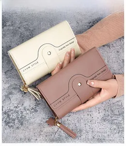 Detail of long tri-fold women's wallets with clover tassel and elegant textures