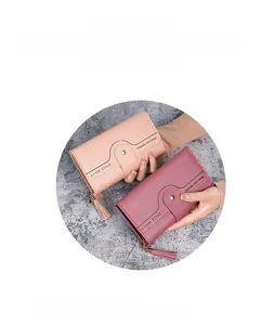 Detail of long tri-fold women's wallet with metal zipper and leather tassel accents
