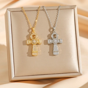 Golden and silver Egyptian Ankh Cross pendants with zircons on jewelry box display